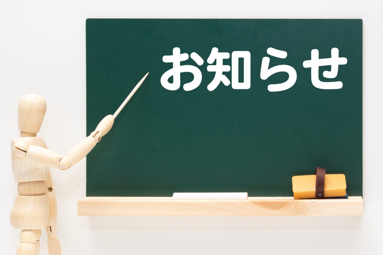お知らせと書かれた黒板と木の人形
